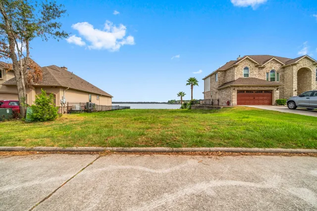 a view of a big house with a yard and plants