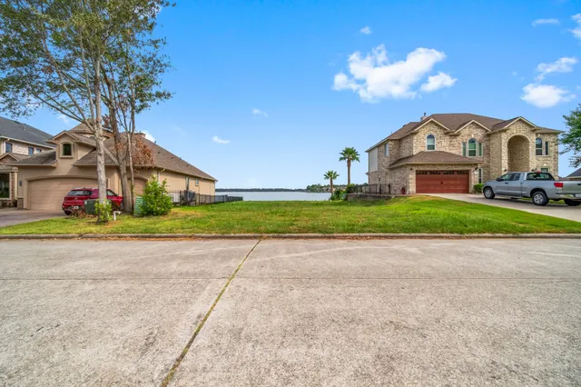 a view of a house with a big yard plants and large trees