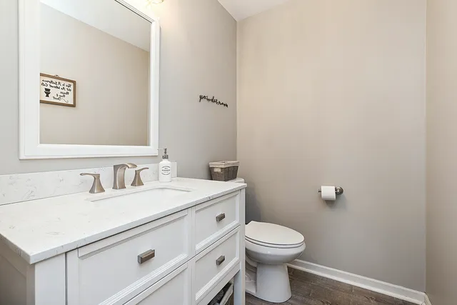 a bathroom with a toilet a sink and mirror