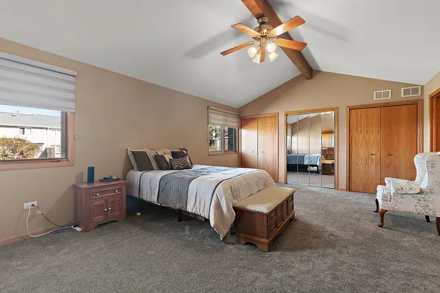 a spacious bedroom with a bed and a chandelier