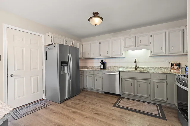 a kitchen with granite countertop cabinets and refrigerator