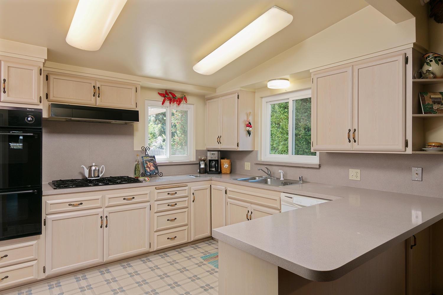 750 South Rice Road Ojai, CA 93023 - Photo 8 of 27 a kitchen with a sink dishwasher and white cabinets with wooden floor