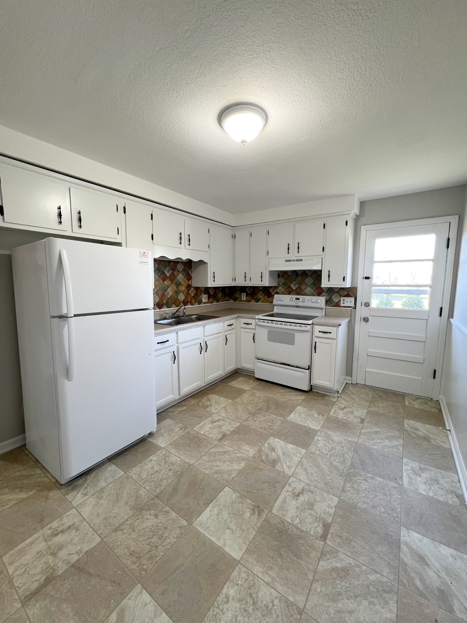 135 Airport Road, Unit C Clarksville, TN 37042 - Photo 6 of 16 a kitchen with granite countertop a refrigerator and a stove top oven