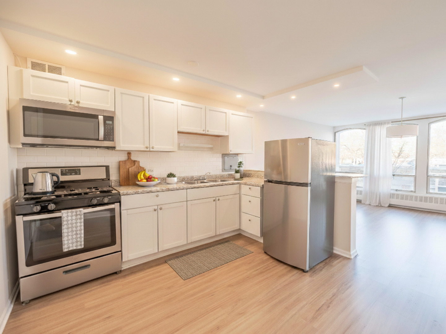 1401 East 55th Street, Unit 211N Chicago, IL 60615 - Photo 4 of 7 a kitchen with stainless steel appliances granite countertop a refrigerator a stove top oven a sink and a granite counter tops with wooden floors