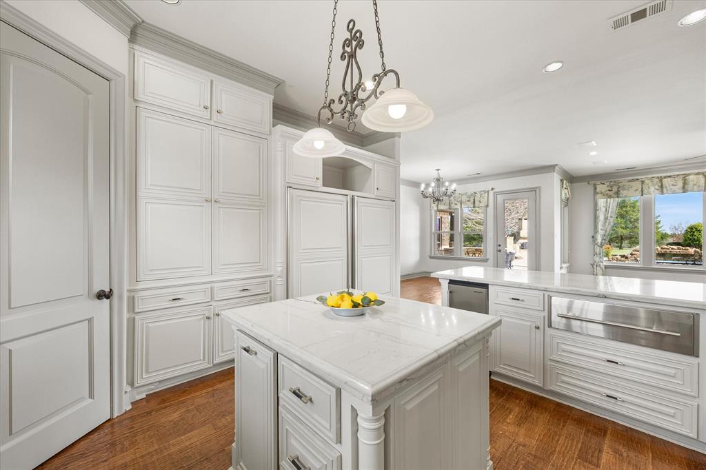 161 Ridgemont Road Heath, TX 75126 - Photo 15 of 40 a kitchen with granite countertop white cabinets and chandelier