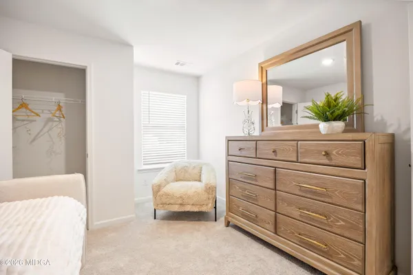 a bedroom with a bed and a mirror on dresser