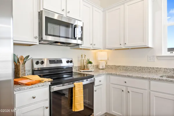 a kitchen with granite countertop a stove sink and microwave