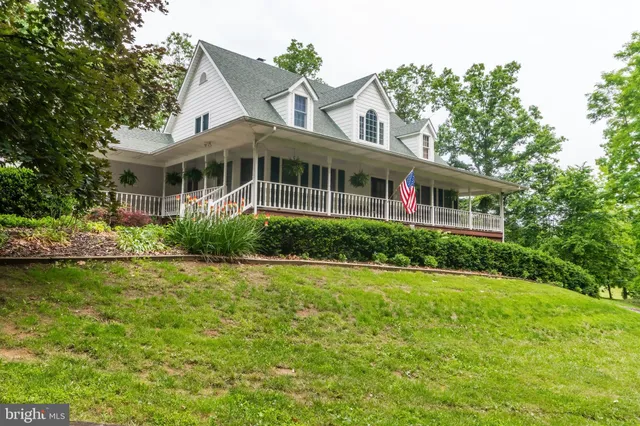 a front view of a house with a yard and potted plants