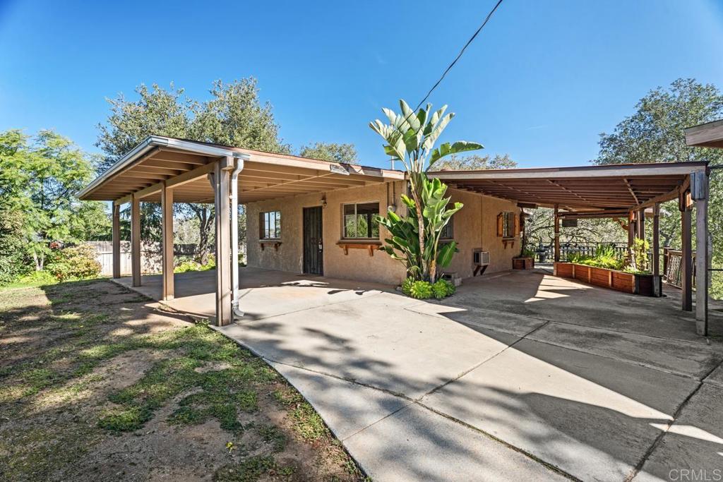 a view of a house with potted plants and a yard