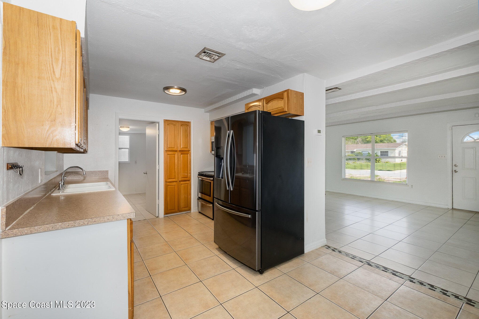 2697 Locksley Road Melbourne, FL 32935 - Photo 8 of 25 a kitchen with a refrigerator sink and cabinets
