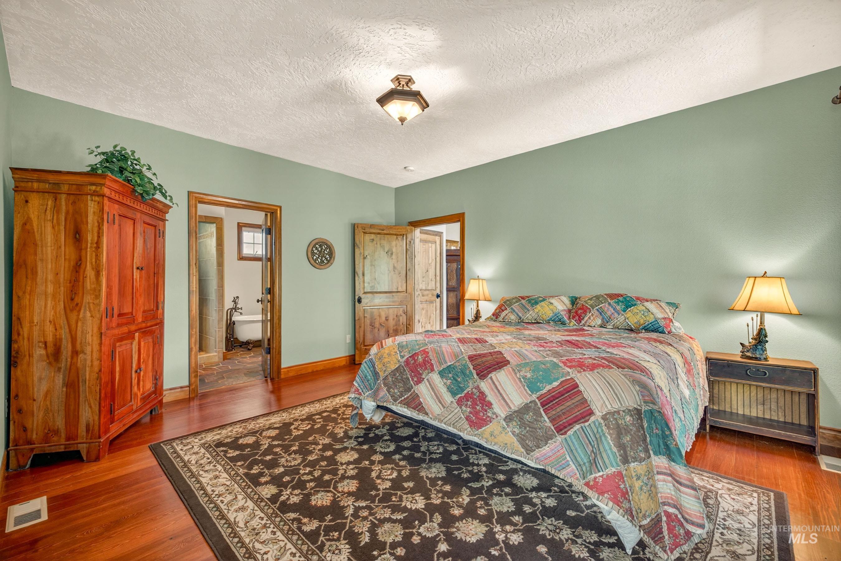 113 Deford Road White Bird, ID 83554 - Photo 18 of 49 Spacious bedroom featuring wood-finish flooring, a neutral wall color, and a textured ceiling