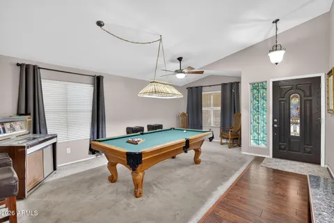 a view of a livingroom with a flat screen tv wooden floor and a ceiling fan