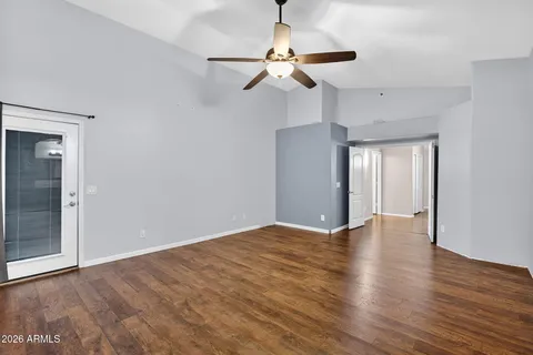 an empty room with a window and a fan