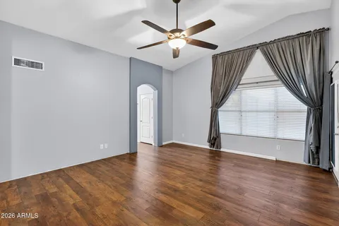 an empty room with a window and ceiling fan