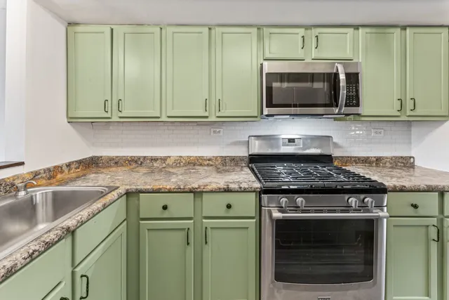 a kitchen with granite countertop a stove and a microwave