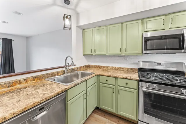 a kitchen with granite countertop a sink and a stove top oven
