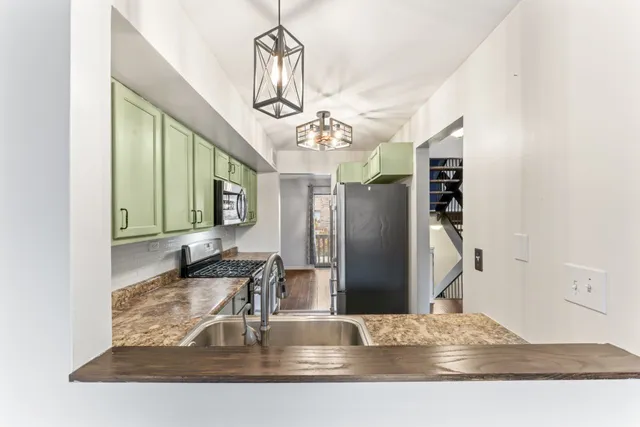 a view of kitchen with granite countertop a refrigerator a sink and dishwasher