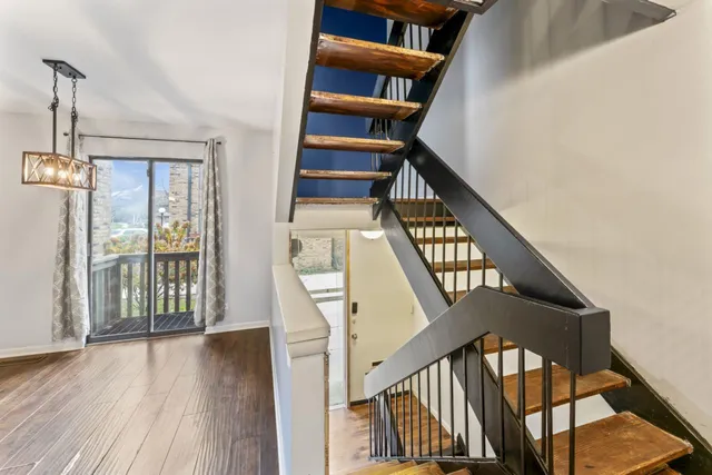 a view of staircase with wooden floor and white walls