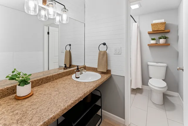 a bathroom with a sink a toilet and shower