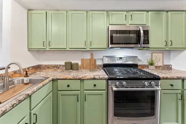 a kitchen with granite countertop a stove and a microwave