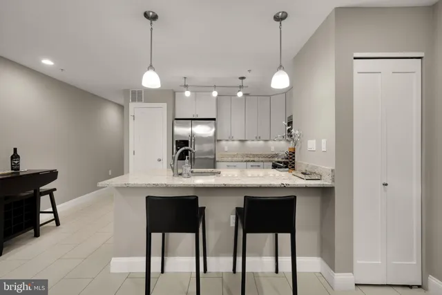 a kitchen with kitchen island granite countertop a sink a center island and cabinets