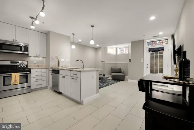 a kitchen with white cabinets and stainless steel appliances