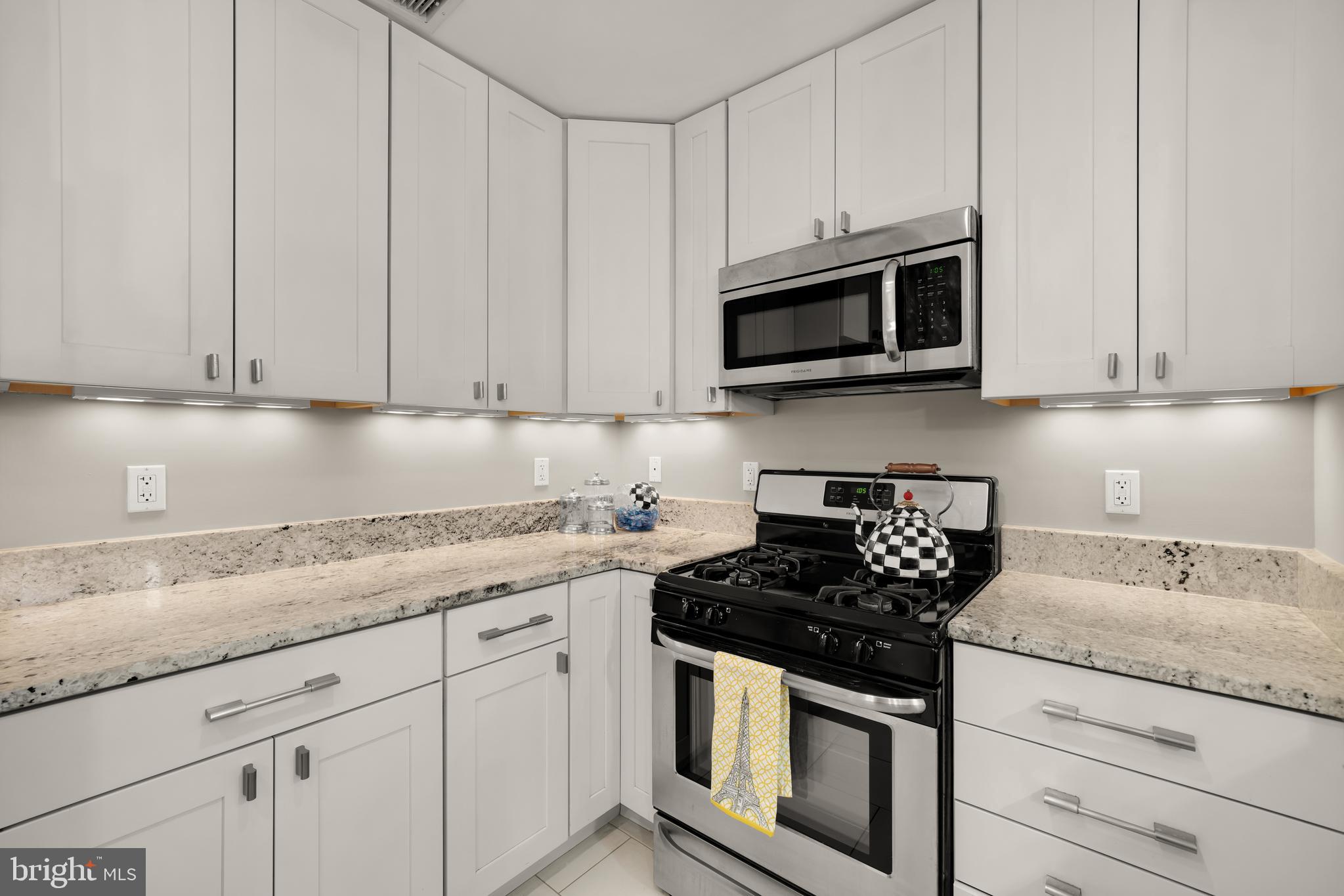 1135 6th Street Northwest, Unit 1 Washington, DC 20001 - Photo 16 of 33 a kitchen with granite countertop white cabinets and stainless steel appliances