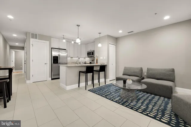 a living room with furniture and kitchen view