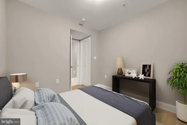 a bedroom with a bed and a potted plant