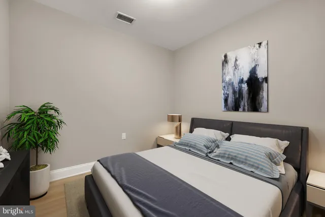 a bedroom with a bed and a potted plant