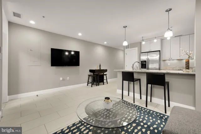 a living room with kitchen furniture and a flat screen tv
