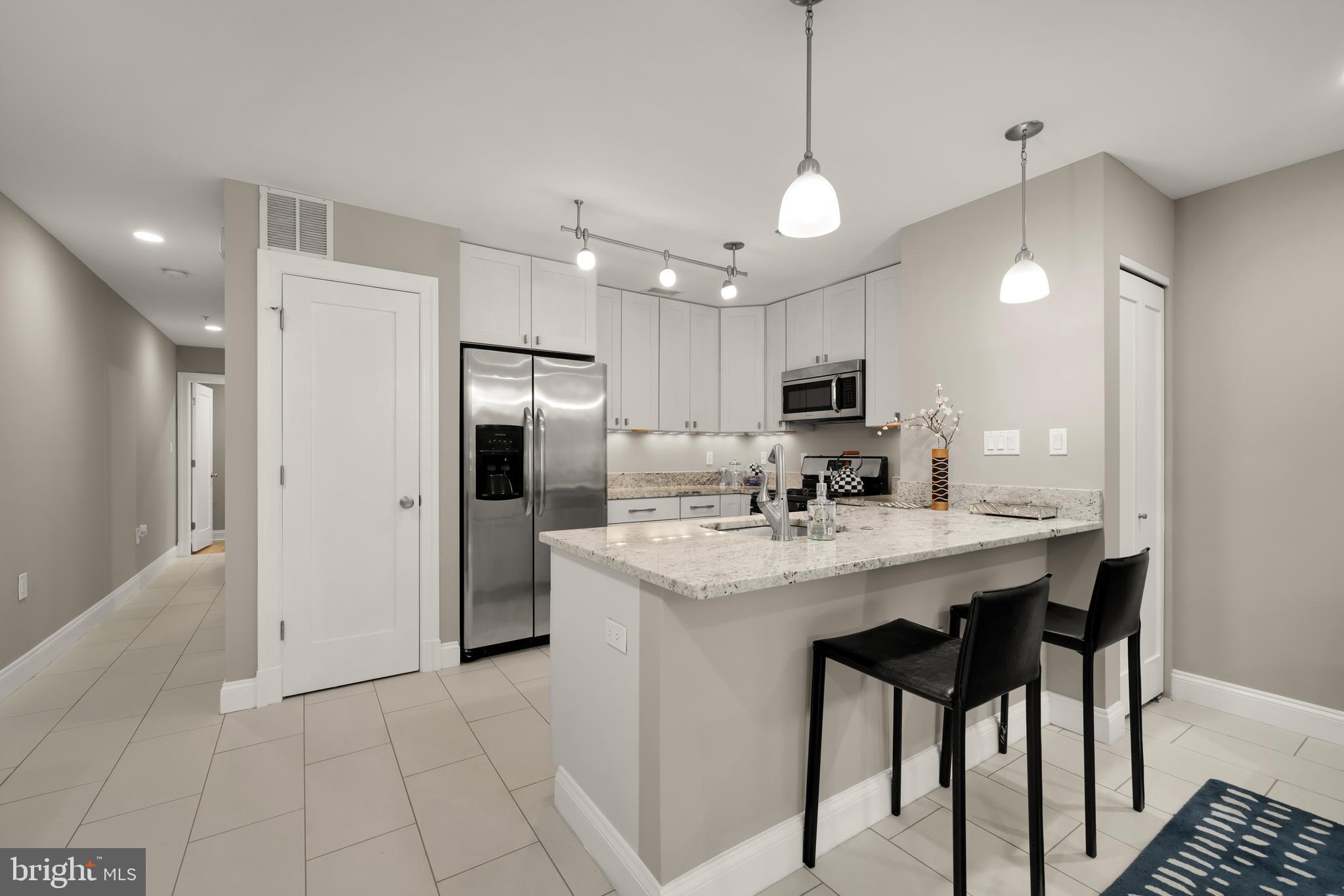 1135 6th Street Northwest, Unit 1 Washington, DC 20001 - Photo 10 of 33 a kitchen with stainless steel appliances granite countertop a refrigerator a sink dishwasher a stove and a refrigerator with wooden floor