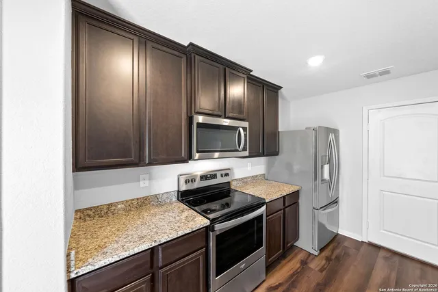 a kitchen with stainless steel appliances granite countertop a refrigerator stove and microwave