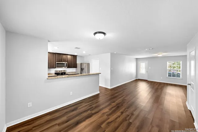 a view of a room with wooden floor and a window
