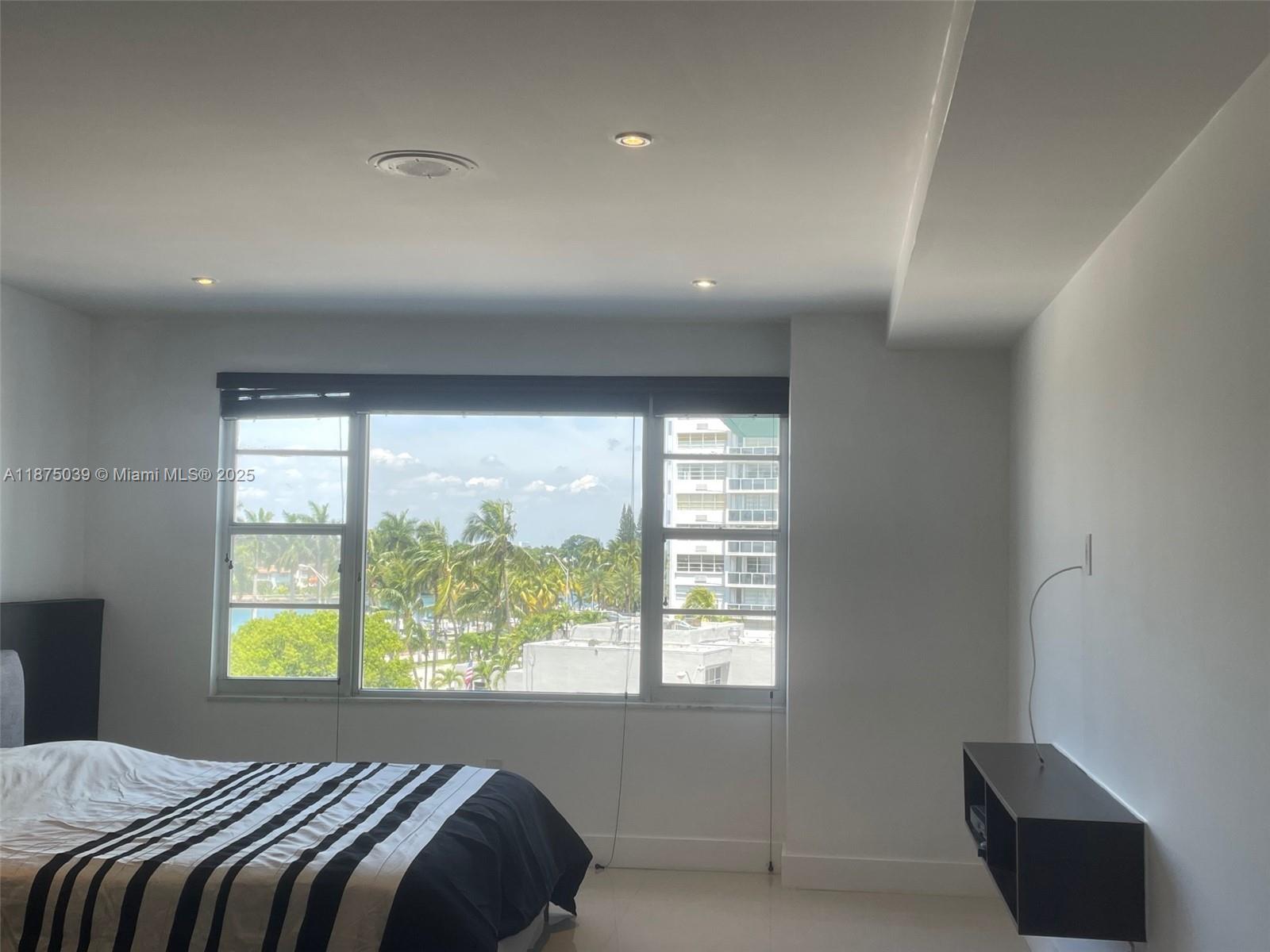 5255 Collins Avenue, Unit 4G Miami Beach, FL 33140 - Photo 14 of 30 a bedroom with a bed and a large window