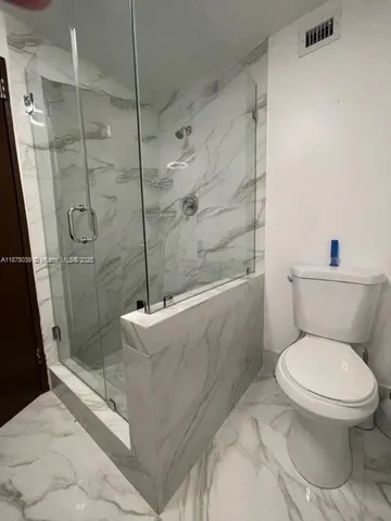 a white toilet sitting next to a bath tub shower