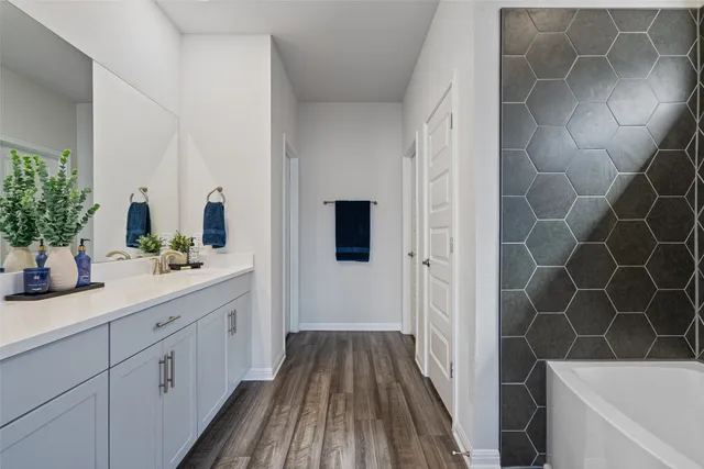 a bathroom with a double vanity sink a large mirror and shower