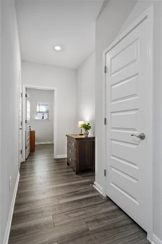a view of a hallway with wooden floor and windows