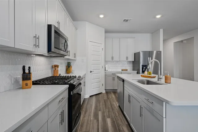 a kitchen with a sink a stove and cabinets
