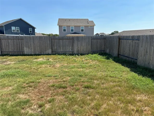a view of a backyard with wooden fence