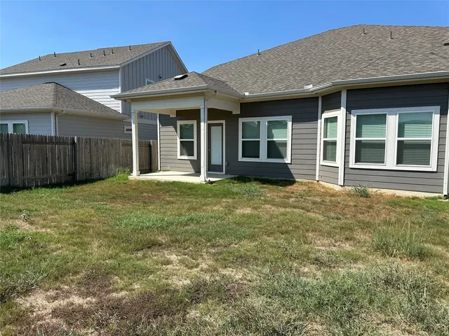 front view of a brick house with a yard
