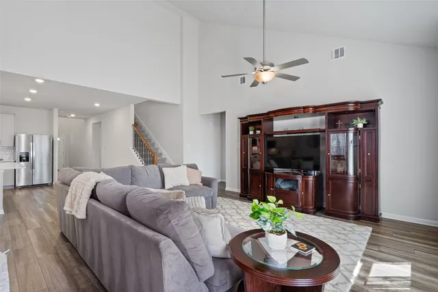 a living room with furniture a flat screen tv and a dining table