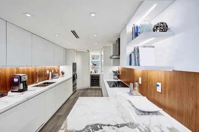 a kitchen with stainless steel appliances kitchen island granite countertop a refrigerator and a sink