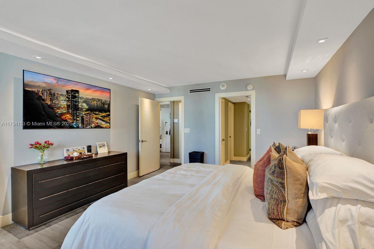 1121 Crandon Boulevard, Unit D706 Key Biscayne, FL 33149 - Photo 24 of 47 a bedroom with a bed and a flat screen tv