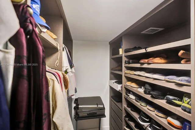 a bedroom with a bed and dresser with wooden floor