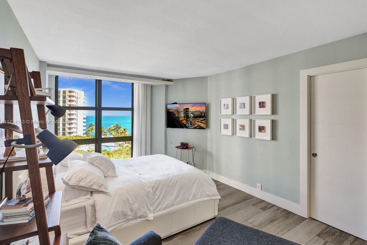 1121 Crandon Boulevard, Unit D706 Key Biscayne, FL 33149 - Photo 28 of 47 a bedroom with a bed and dresser with wooden floor