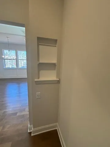 a view of empty room with window and wooden floor