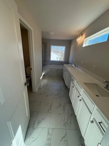 a spacious bathroom with a double vanity sink and a mirror