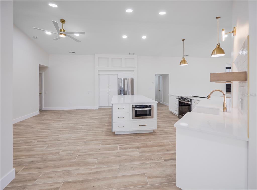 6790 Edgeworth Drive Orlando, FL 32819 - Photo 13 of 57 a large white kitchen with wooden floor