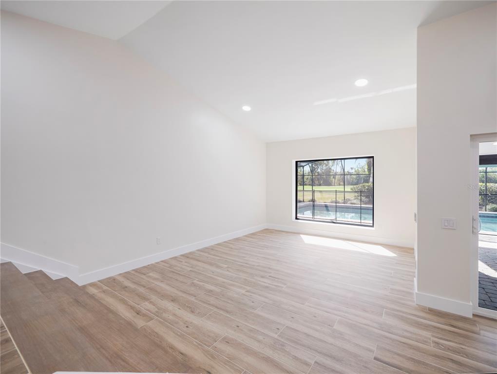 6790 Edgeworth Drive Orlando, FL 32819 - Photo 17 of 57 an empty room with wooden floor and windows